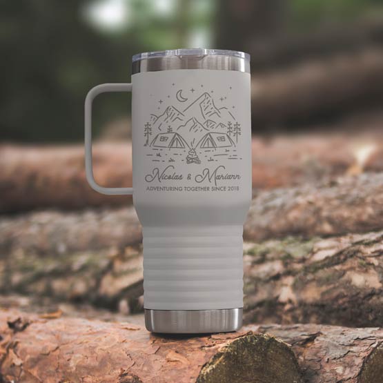 White Stainless Steel Coffee Tumbler With Handle And Engraving Of Camping Art And Names And Date On Wood Log Outdoors