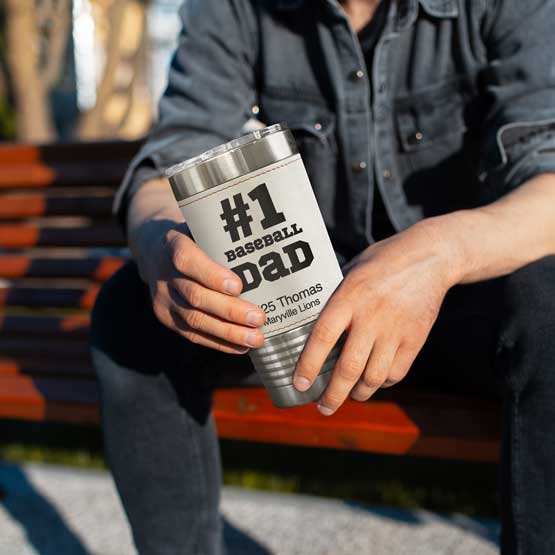 Man On Park Bench Holding Faux Leather Wrapped Coffee Tumbler With Baseball Theme And Number One Baseball Dad Message