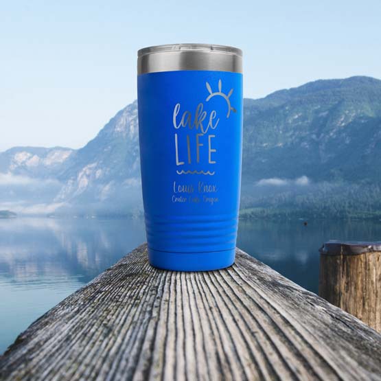 Blue 20 Ounce Tumbler Engraved With Beach Life Text And Beach Art And Family Name And Beach Name On Wood Dock Rail Near Lake