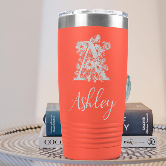 Coral Twenty Ounce Stainless Steel Coffee Tumbler Engraved With Name And Monogram And Flower Art On A Side Table With Books