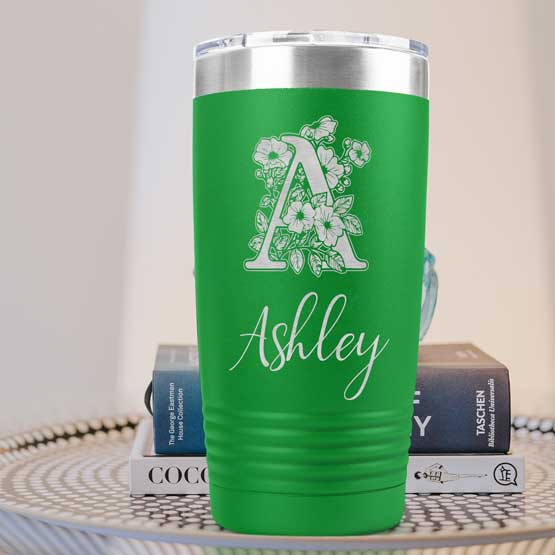 Custom Green Twenty Ounce Stainless Steel Coffee Tumbler Engraved With Ashley And Monogram And Flower Art On Table With Books