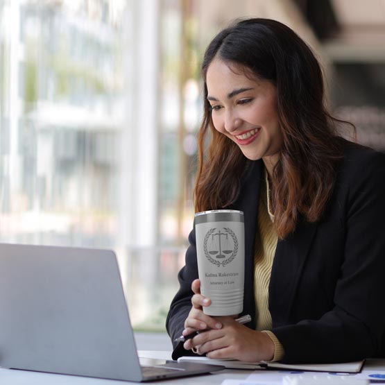 Woman Working At Desk With White 20 Ounce Tumbler Engraved With Justice Scales And Name And Attorney At Law Beside Laptop