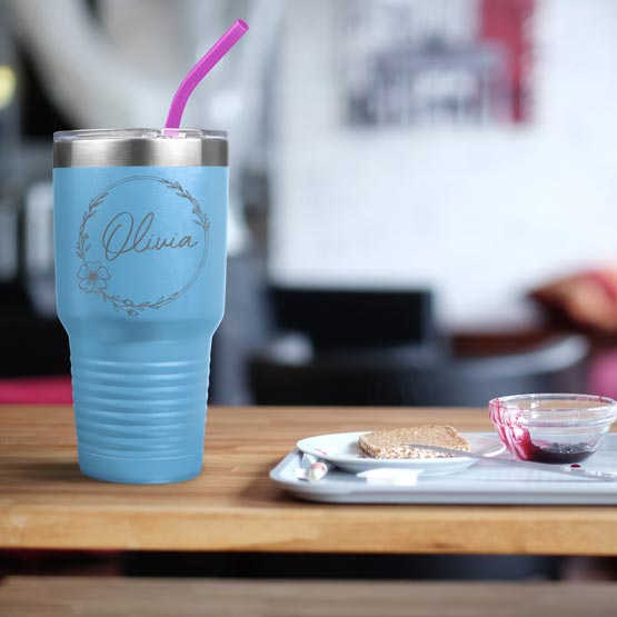 Light Blue Thirty Ounce Coffee Tumbler With Straw And Engraved With Name And Flower Art On Table With Food Platter