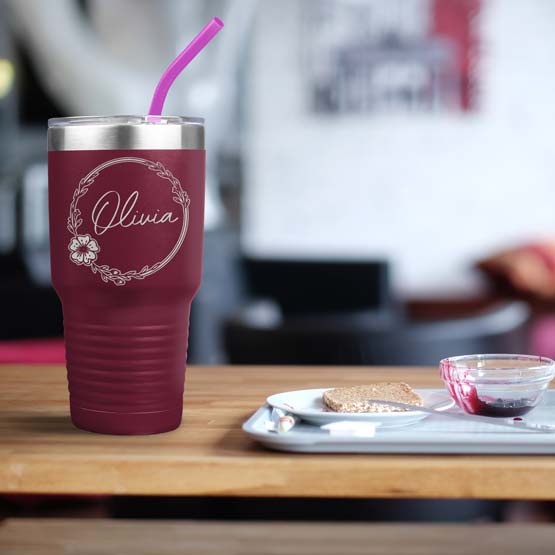Custom Maroon Thirty Ounce Coffee Tumbler With Straw And Engraved With Name And Flower Art On Table With Food Platter