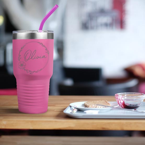 Pink Thirty Ounce Stainless Steel Coffee Tumbler With Straw And Engraved With Name And Flower Art On Table With Food Platter