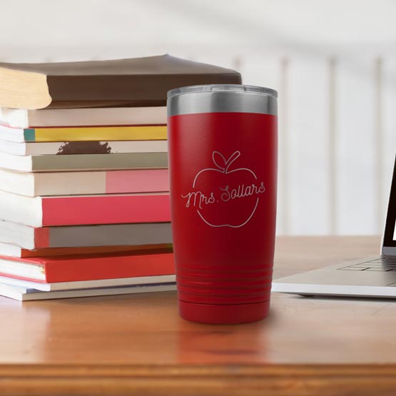 Red 20 Ounce Stainless Steel Tumbler Engraved With Teacher Name Inside Apple Artwork On Desk With Books And Laptop