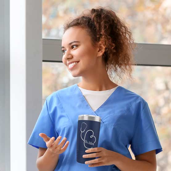 Nurse Standing Near Window Holding Navy Blue 20 Ounce Stainless Steel Tumbler Engraved With Name Inside Stethoscope Art