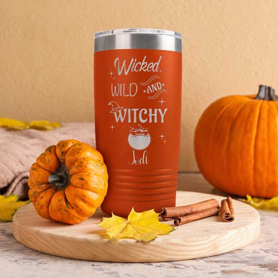 Orange 20 Ounce Tumbler Engraved With Wicked Wild And Witchy Text And Cauldron Art And Name On Kitchen Counter With Pumpkins