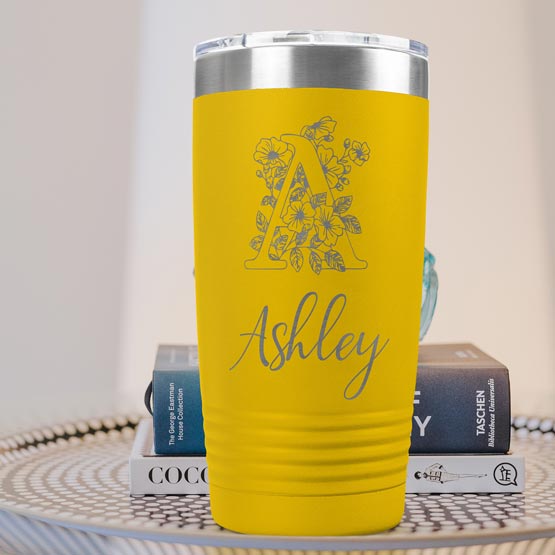 Yellow Twenty Ounce Stainless Steel Coffee Tumbler Engraved With Ashley And Monogram And Flower Art On Table With Books