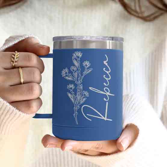 Woman Hands Holding Blue Stainless Steel Coffee Tumbler Mug With Handle And Engraved With Name And Flower Art