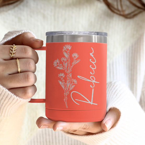 Woman Hands Holding Coral Stainless Steel Coffee Tumbler Mug With Handle And Engraved With Name And Flower Art
