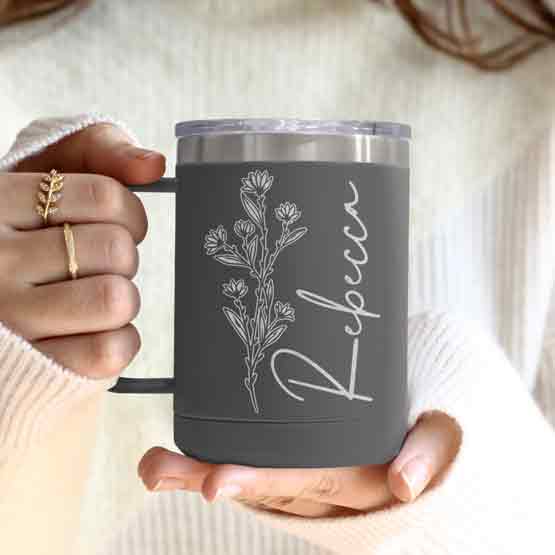 Woman Hands Holding Gray Stainless Steel Coffee Tumbler Mug With Handle And Engraved With Name And Flower Art
