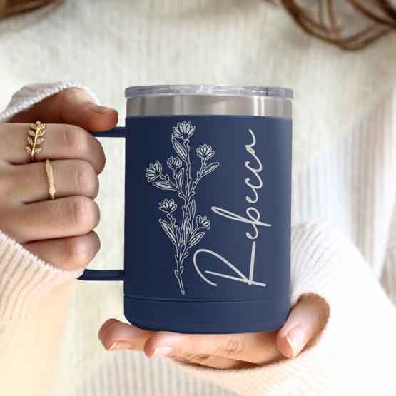 Woman Hands Holding Navy Blue Stainless Steel Coffee Tumbler Mug With Handle And Engraved With Name And Flower Art