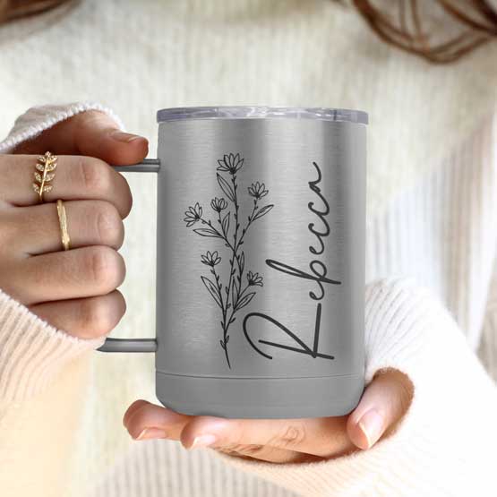 Woman Hands Holding Silver Stainless Steel Coffee Tumbler Mug With Handle And Engraved With Name And Flower Art