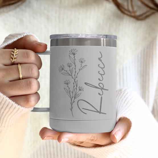 Woman Hands Holding White Stainless Steel Coffee Tumbler Mug With Handle And Engraved With Name And Flower Art