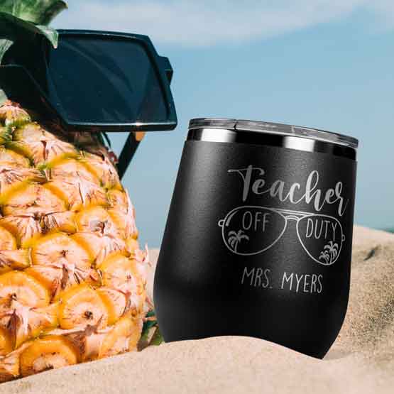 Black 12 Ounce Stemless Wine Tumbler Engraved With Sunglasses Art And Teacher Off Duty And Name On Beach Near Pineapple