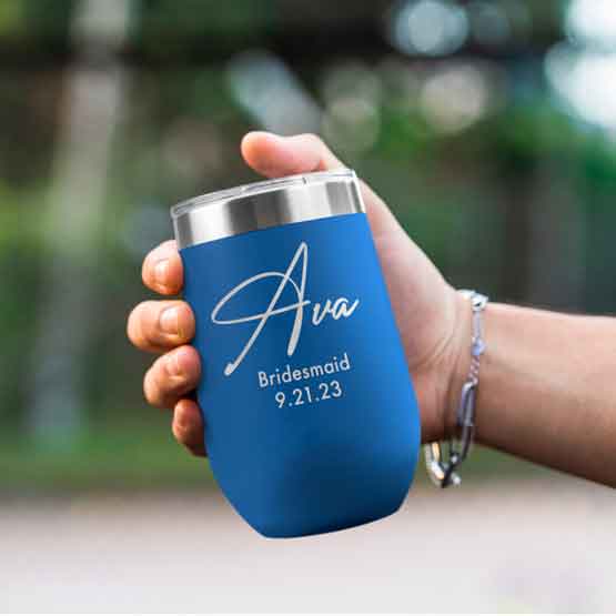 Woman Hand Outdoors Holding Custom Blue Stemless Wine Tumbler Engraved With Name And Date And Bridesmaid Text