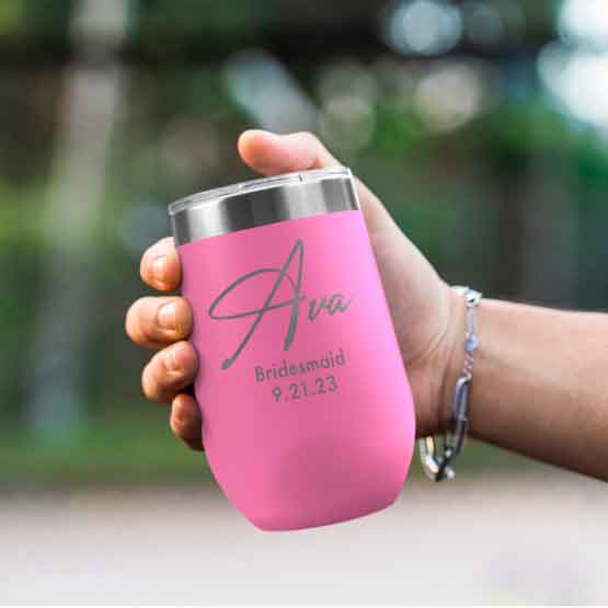 Woman Hand Outdoors Holding Custom Pink Stemless Wine Tumbler Engraved With Name And Date And Bridesmaid Text