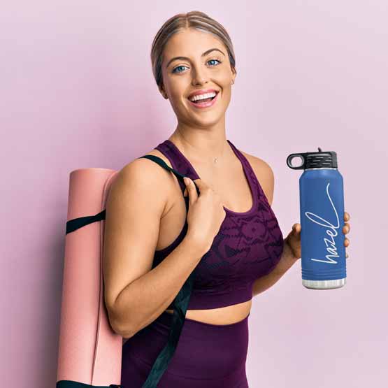 Woman In Workout Clothes Carrying Yoga Mat And Blue Thirty Two Ounce Water Bottle With Straw And Engraved Name