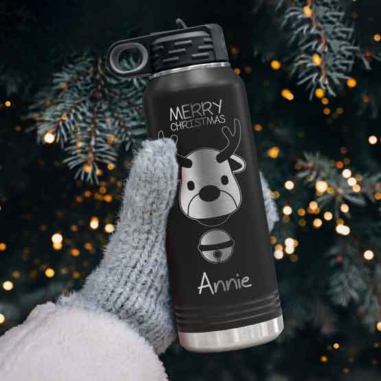 Hand In Mitten Near Christmas Tree Holding Custom 32 Ounce Black Water Bottle With Reindeer Art And Name And Merry Christmas