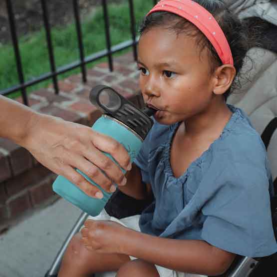 Hand Serving Teal Stainless Steel Child Water Bottle With Straw And Engraved Name To Little Girl In Stroller Outdoors