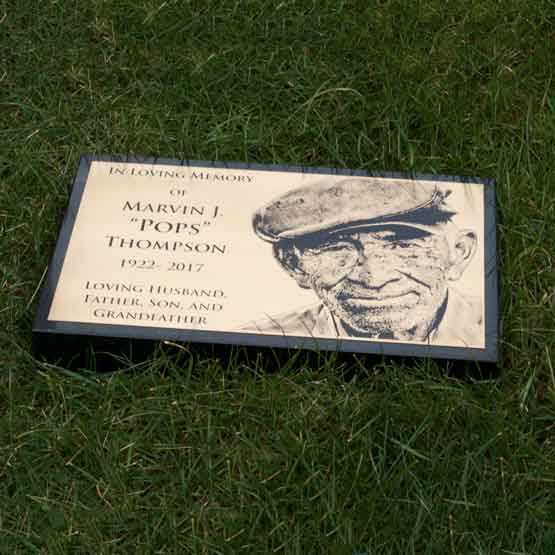 Custom Engraved Bronze Headstone On Granite Set In Grass.