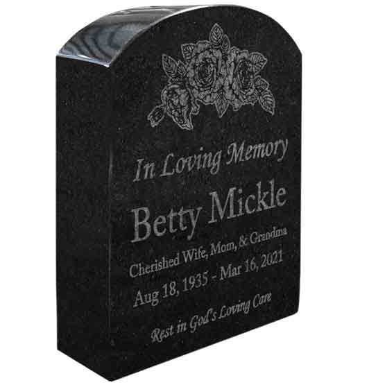 Tombstone Shaped Granite Headstone Engraved With Flower Art And Memorial Message For Betty Mickle Against White Background