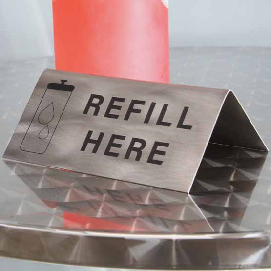 Custom Engraved Titanium Table Tent On Metal Table Near Water Bottle.