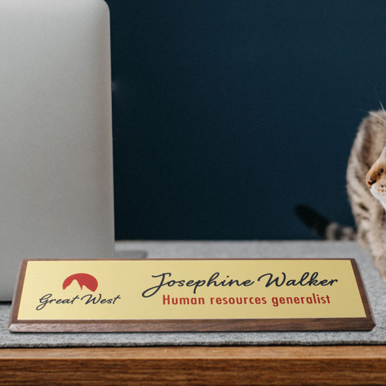 Same Day Walnut Desk Wedge With Gold Aluminum Plate Printed With Logo And Employee Details On Work Desk With Cat And Laptop