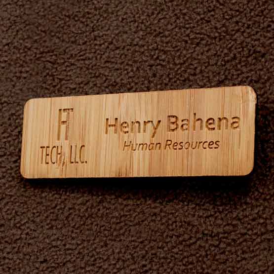 Engraved Bamboo Wood Name Tag With Engraved Logo On Brown Sweater.