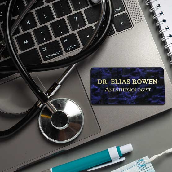 Custom Engraved Aluminum Medical Name Tag In Blue Marble Metal Color On Laptop Near Stethoscope. 