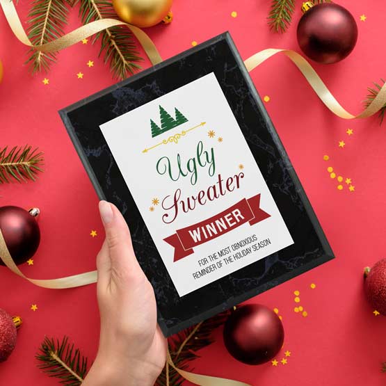 Woman Holding Ugly Sweater Winner Plaque Over Ornaments And Ribbons.