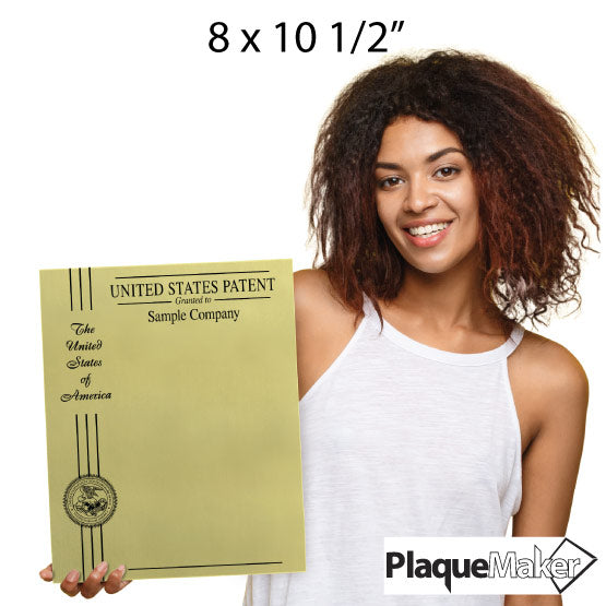 Woman Holding Custom Gold Aluminum Wall Patent Plaque With Seal And Ribbon On Left Side Above PlaqueMaker Logo