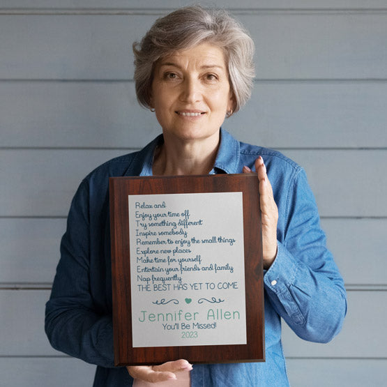 Happy Older Woman Holding Custom Silver Aluminum Plaque With Retirement Acronym Message On A Wood Board With Names And Year