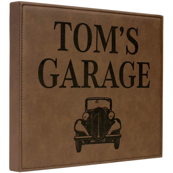 Dark Brown Faux Leather Plaque Laser Engraved With Tom’s Garage Text And Car Artwork Against A White Background