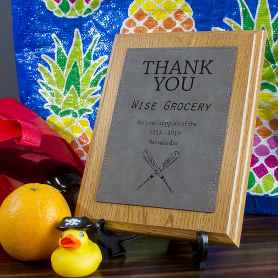 Plaque With Wood Board And Gray Faux Leather Plate Engraved With Thank You Message On Shelf Via Easel Near Tote Bag