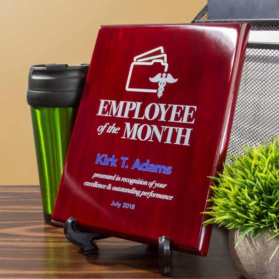 Custom Rosewood Piano Finish Plaque Award For Employee Of The Month Standing Via Easel On Wood Shelf By Mug And Plant
