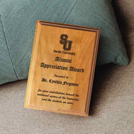 Solid Cherry Plaque Award For Appreciation With Message And University Logo Sitting On Carpet And Blue Pillow