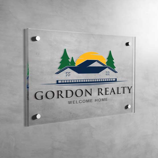 Custom Clear Acrylic Sign With Full Color Artwork Of Realty Logo And Company Text Mounted On Gray Wall