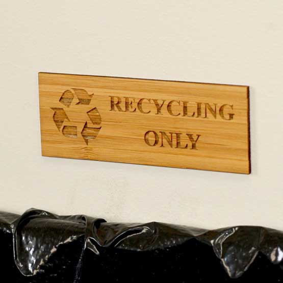 Rectangle Bamboo Label Laser Engraved With Recycling Icon And Recycling Only Message Mounted On Wall Above Bin