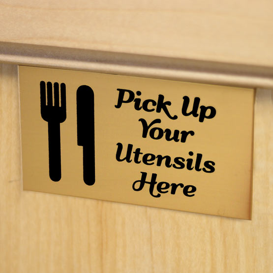 Bronze Rectangle Label Laser Fused With Utensils Art And Pick Up Your Utensils Here Message Mounted On Wood Counter