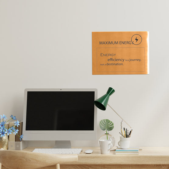 Bronze Rectangle Sign Laser Fused With Maximum Energy Logo And Slogan On Office Wall Above Desk With Computer And Lamp