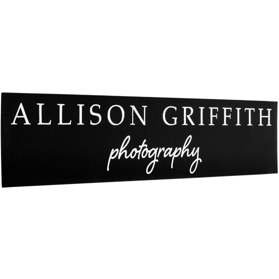 Custom Black And Silver Faux Leather Sign Laser Engraved With Allison Griffith Photography Message Against White Background