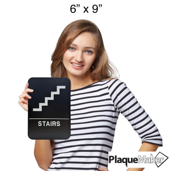 Size Guide Of Woman Holding 6 By 9 Black And White Plastic Sign With Stairs Icon Above Corresponding Text And Braille