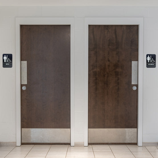 Two Public Bathrooms With Black And White Plastic Signs For Men’s Restroom And Women’s Restroom With Wheelchair Access